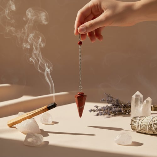 Pendule divinatoire conique en jaspe rouge suspendu à une chaînette